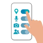 Hand that taps permission toggles on a phone screen to check app permissions