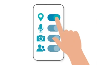 Hand that taps permission toggles on a phone screen to check app permissions